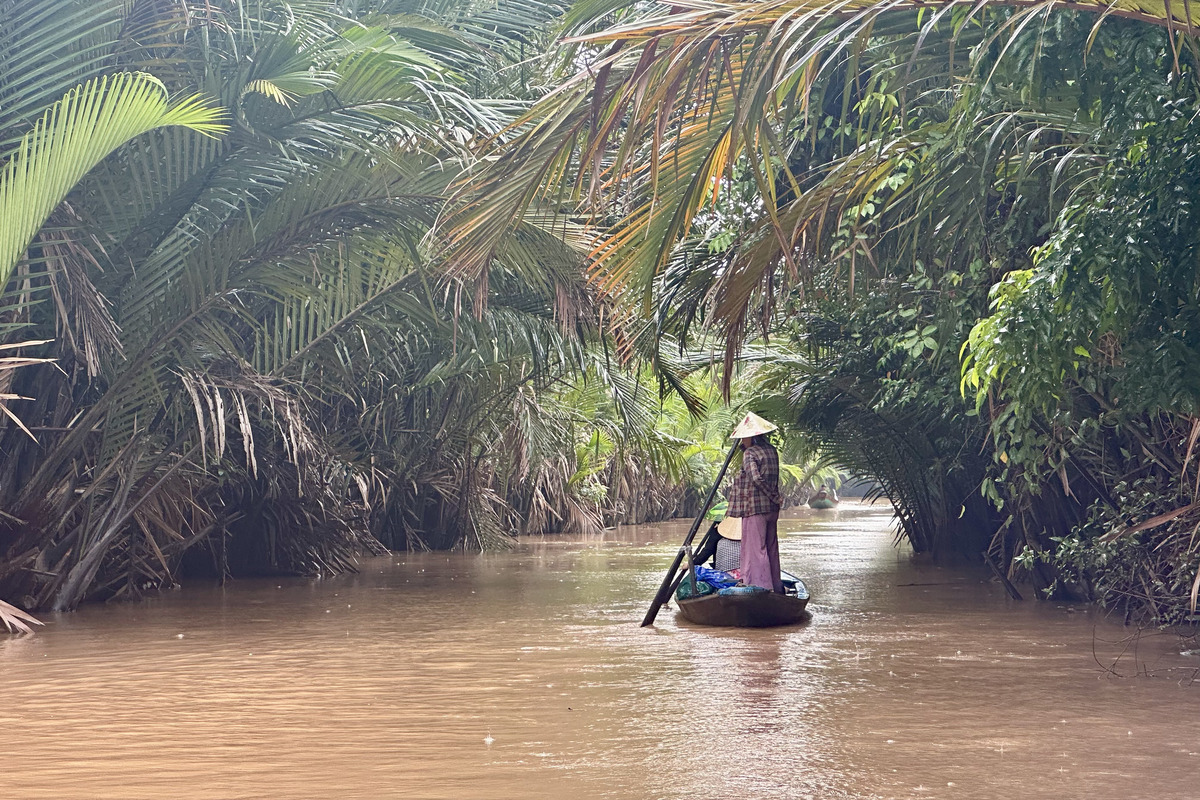 Boat traveling through a quiet canal in the Mekong Delta