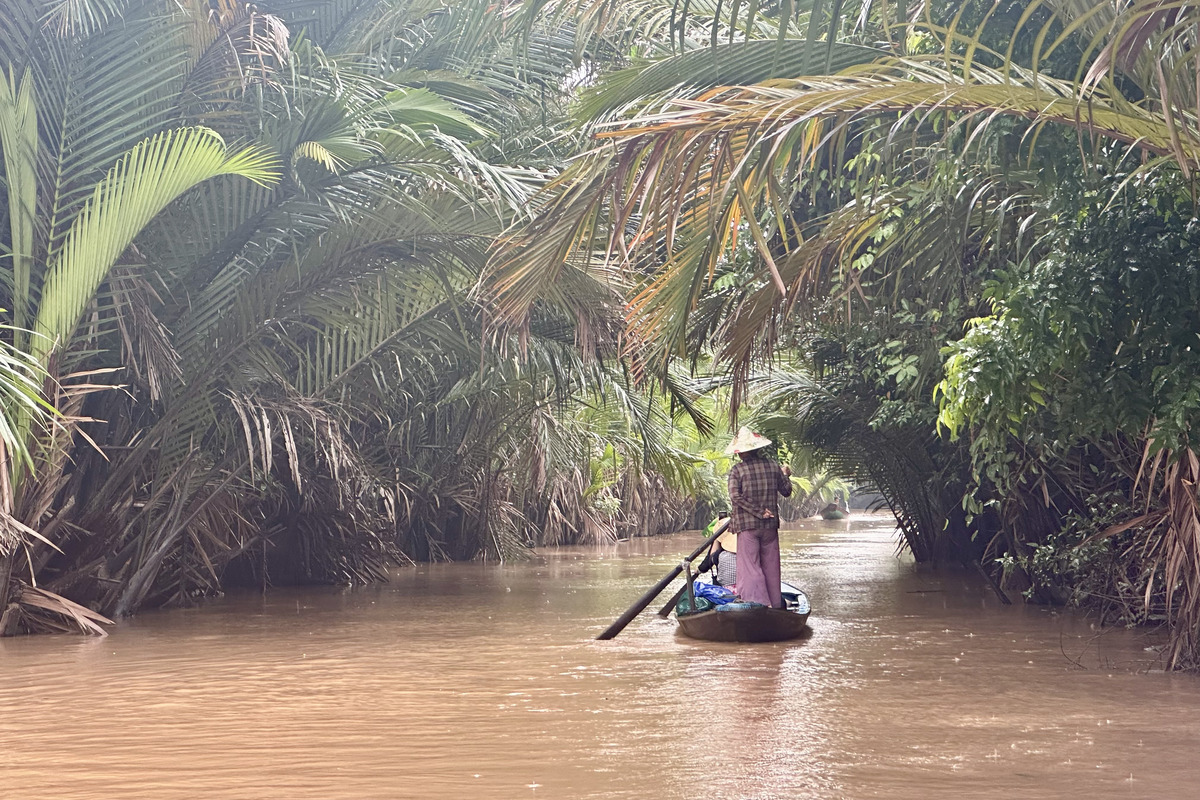 Boat passing through a quiet canal on a scenic Mekong Delta day trip