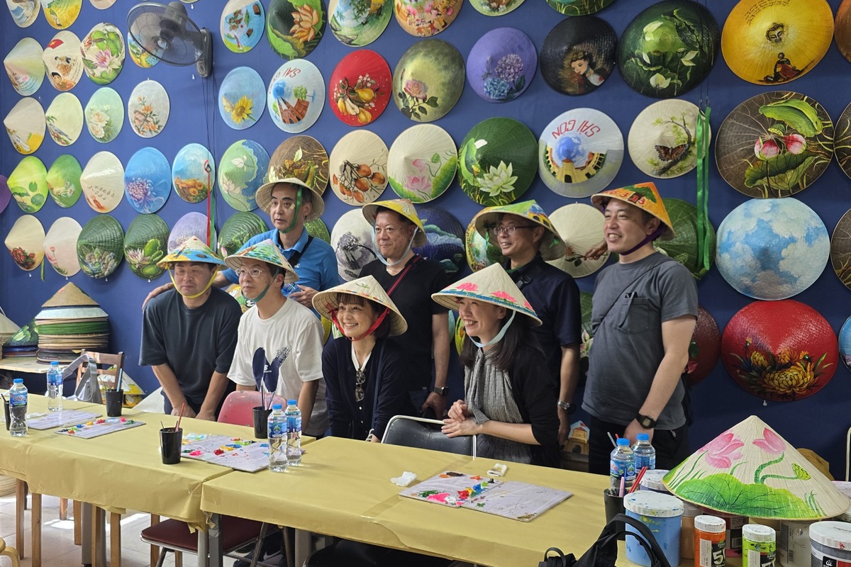 Travelers joining a Vietnamese conical hat painting workshop at Suntrail Gallery