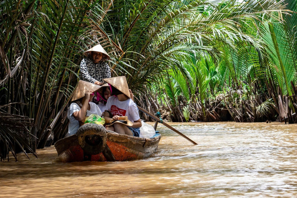 Small group enjoying coconuts on a Mekong Delta river boat tour