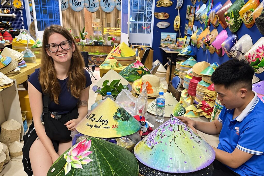 Traveler showing her hand-painted conical hat at a conical hat painting workshop in Saigon